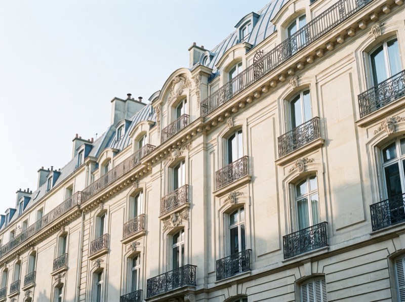 Façade d'immeuble haussmannien en pierre de taille avec balcons en fer forgé